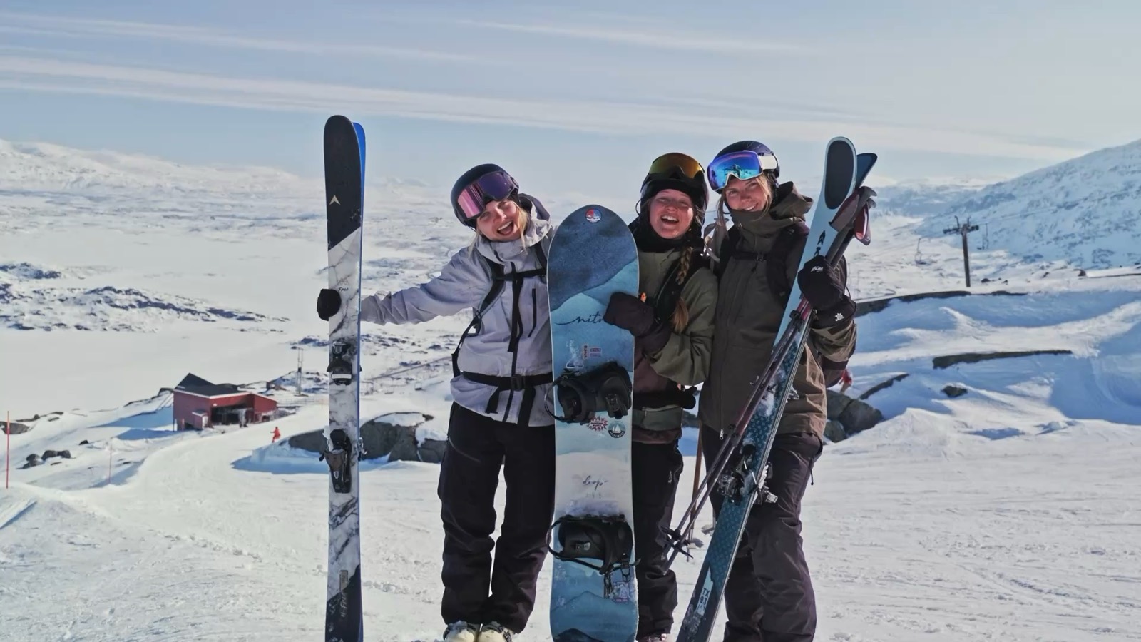 Tre vänner med skidor och snowboard på fjället